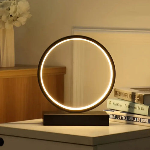Lampe LED circulaire minimaliste allumée sur une table de chevet